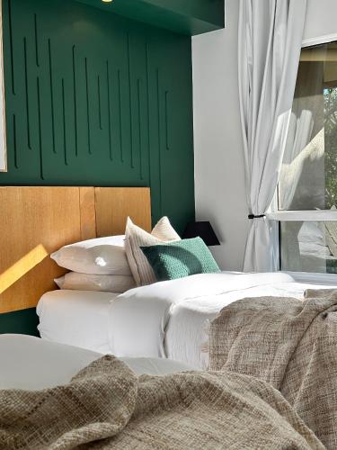 two beds in a bedroom with a green wall at Luxury 2 Bedroom apartment, Treetop views, Resort with 4 swimming pools in Cairns North