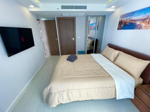 a bedroom with a large bed and a flat screen tv at Large 2 BR Condo, Grand Avenue, Central Pattaya in Pattaya