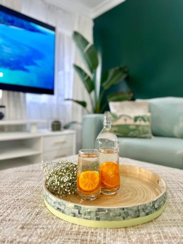two glasses of orange juice on a tray on a table at Luxury 2 Bedroom apartment, Treetop views, Resort with 4 swimming pools in Cairns North