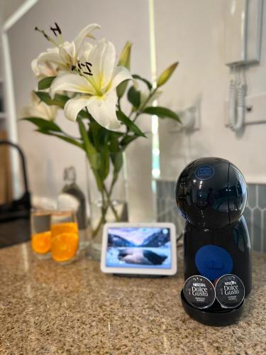 a kitchen counter with a blender and a vase with a flower at Luxury 2 Bedroom apartment, Treetop views, Resort with 4 swimming pools in Cairns North