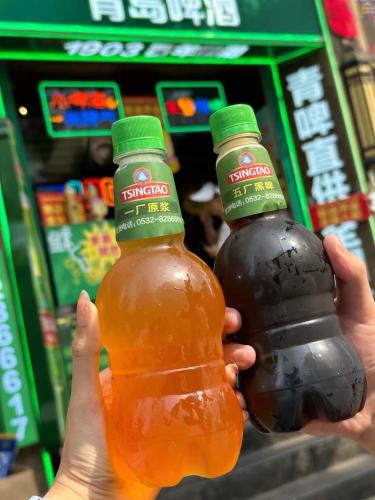 two people holding up two bottles of honey at MG Hotel St Michael's Cathedral, Qingdao in Qingdao
