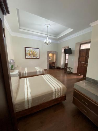 a bedroom with a bed and a television in it at Hotel Cantera Real, Morelia in Morelia