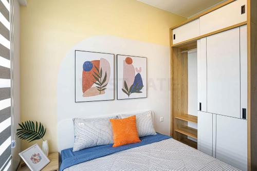 um quarto com uma cama com uma almofada laranja em Westgate Apartment- 2N House em Ho Chi Minh