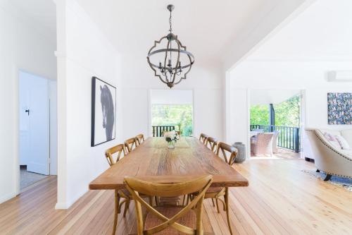 a dining room with a wooden table and chairs at La Villette sleeps 9 fireplace BBQ Pet Friendly in Katoomba