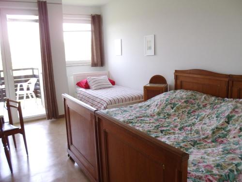 a bedroom with a bed and a chair and a window at Ferienwohnung Mostecky in Ferlach