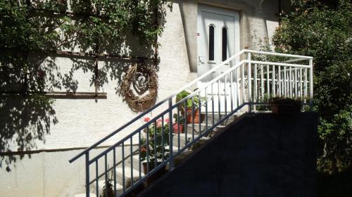 a white staircase leading up to a door with plants at Ferienwohnung Mostecky in Ferlach