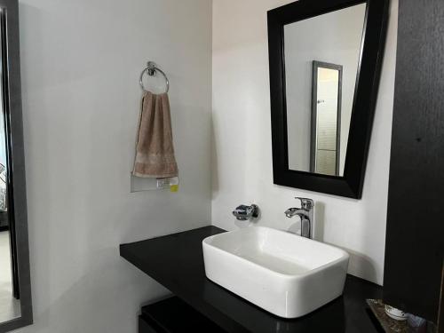a bathroom with a white sink and a mirror at Aparta hotel Le Soleil in Cartagena de Indias