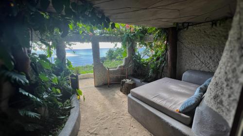 a bed in a room with a view of the ocean at Rockwater Resort in Tanna Island