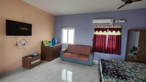 a living room with a couch and a television at sannidhi homestay 1bhk and 2bhk apartment in Tirupati