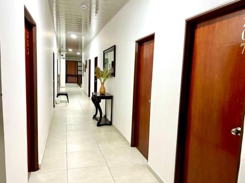 a corridor of a hallway with a door and a table at Hotel Dorado Real HDR in Popayan