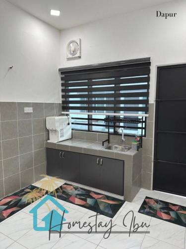 eine Küche mit einem Waschbecken und einem Fenster in der Unterkunft Homestay Ibu in Lumut