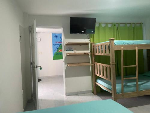 a small room with a bunk bed and a television at Hostel ISABELLA in Santa Marta