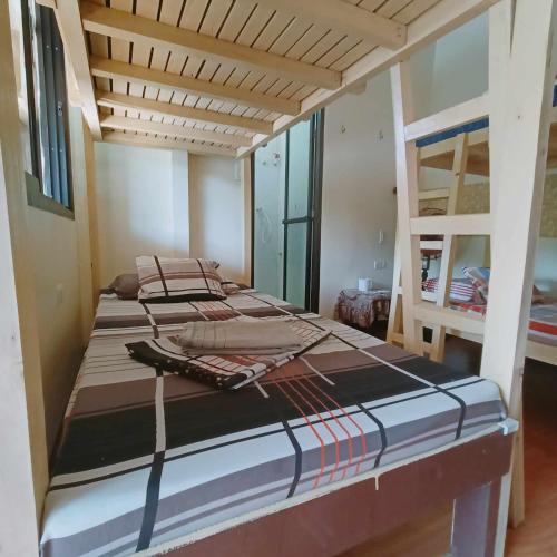 a bedroom with two bunk beds and a ladder at El Gordo's Seaside Adventure Lodge in El Nido