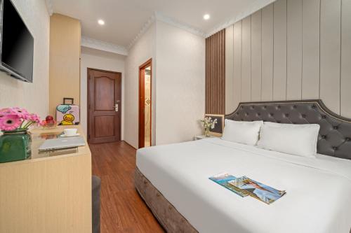 um quarto de hotel com uma cama grande e uma secretária em Be U Hotel City View em Da Lat