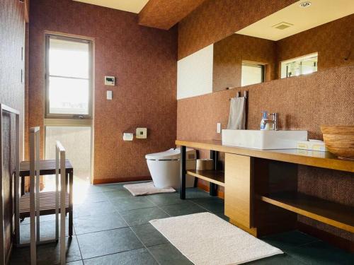 a bathroom with a sink and a toilet at Ocean View Luxury Beach House - Enjoy Spring Cherry Blossoms, Beaches and BBQ at a Luxury Home in Shimoda