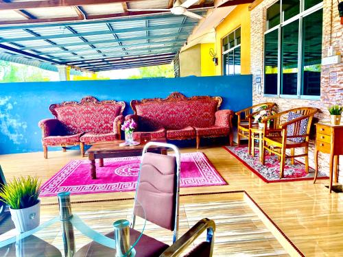 een woonkamer met banken en een tafel en stoelen bij Danisha Homestay in Kampong Baru