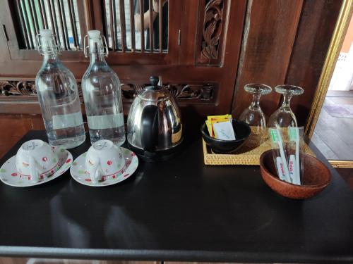 a table with two bottles and cups and a tea kettle at Bujak Permai Villa Matahari Lombok NTB in Praya