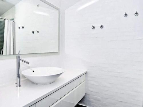 a white bathroom with a sink and a mirror at Holiday home Skagen VIII in Skagen
