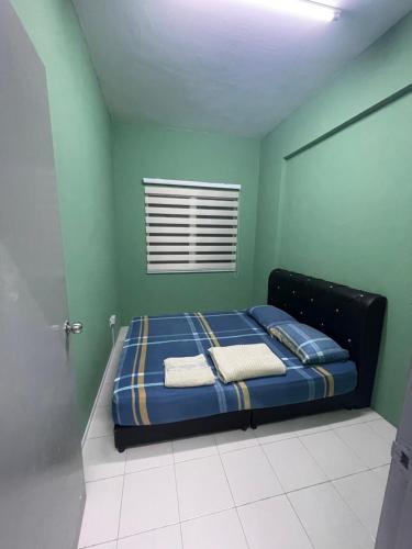 a bed in a green room with two pillows at Alfaruqi Homestay Seaview in Beserah
