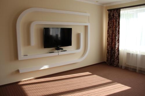 a room with a flat screen tv on a wall at Mіnі Gotel Pozitiv in Horodets'ke