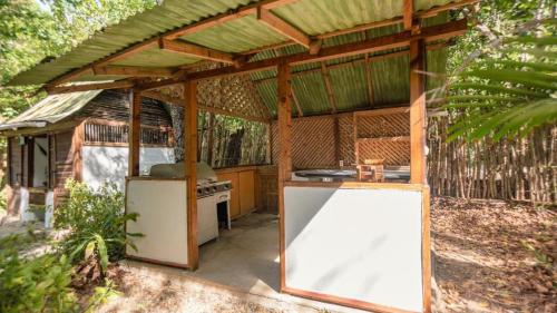 an outdoor kitchen with a stove and a pavilion at Hotel Playa Scondida Barú in Baru