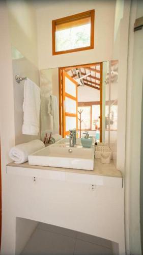 a bathroom with a sink and a mirror at Hotel Playa Scondida Barú in Baru