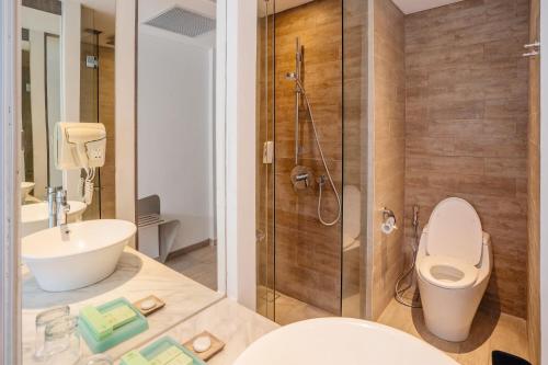 a bathroom with a toilet and a sink and a shower at Kamaniiya Petitenget Seminyak in Seminyak