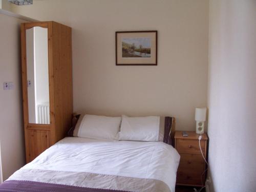 1 dormitorio con 1 cama y una foto en la pared en Denecrest Guest House, en Windermere