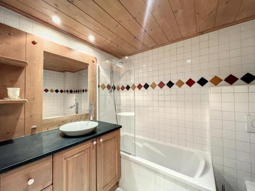 uma casa de banho com um lavatório e uma banheira em Appartement Chamonix-Mont-Blanc, 3 pièces, 6 personnes - FR-1-507-76 em Chamonix-Mont-Blanc