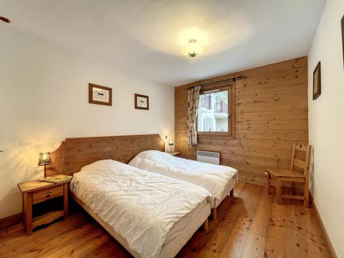 ein Schlafzimmer mit einem Bett und einer Holzwand in der Unterkunft Chamonix: Appartement 3 pièces avec parking et wifi, 6 pers - FR-1-507-76 in Chamonix-Mont-Blanc