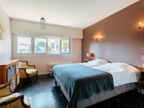 une chambre avec un lit et un bureau et deux fenêtres dans l'établissement Villa familiale 7 pièces à Carnac - 10 pers, piscine chauffée, jardin, proche plage et commerces - FR-1-477-242, à Carnac