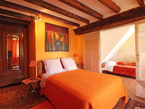 um quarto com uma cama laranja num quarto em Gîte Appenai-sous-Bellême, 5 pièces, 11 personnes - FR-1-497-186 em Appenai-sous-Bellême