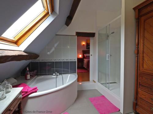 uma casa de banho com uma banheira e um chuveiro em vidro. em Gîte Appenai-sous-Bellême, 5 pièces, 11 personnes - FR-1-497-186 em Appenai-sous-Bellême