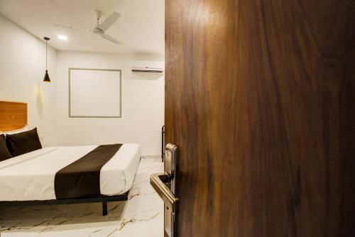a bedroom with a bed and a wooden door at Super Townhouse Rcc Hotel Banjara Hills in Hyderabad