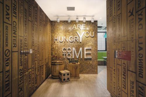 a room with a wall with a sign that says arehung crore at Kamaniiya Petitenget Seminyak in Seminyak