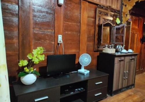 Habitación con escritorio, TV y espejo. en Bujak Permai Villa Matahari Lombok NTB en Praya