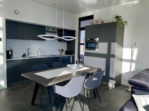 エンクホイゼンにあるEnkhuizer Strand Chalet Beach Oase Erste Reihe mit Zaun Haus Nr 248のキッチンにテーブルと椅子がある