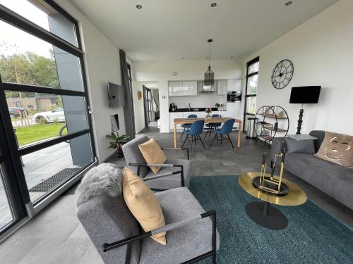 un soggiorno con un divano e un tavolo di Enkhuizer Strand Chalet Sunkiss Dritte Reihe Haus Nr 217 a Enkhuizen