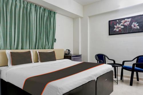 - une chambre avec un lit, une table et des chaises dans l'établissement Hotel Seven Hills, à Dāpuri