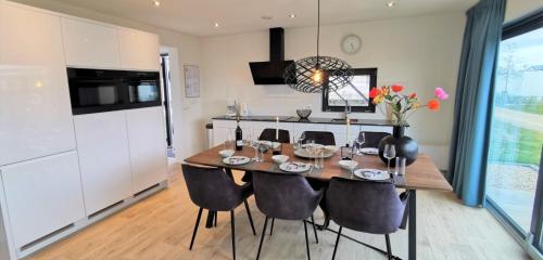 a dining room with a table and chairs in a kitchen at Enkhuizer Strand Cube Elite Estel mit Dachterrasse und Zaun Haus Nr 337 in Enkhuizen