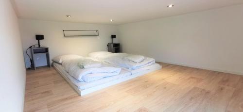 a white room with a bed with white sheets at Enkhuizer Strand Cube Elite Estel mit Dachterrasse und Zaun Haus Nr 337 in Enkhuizen
