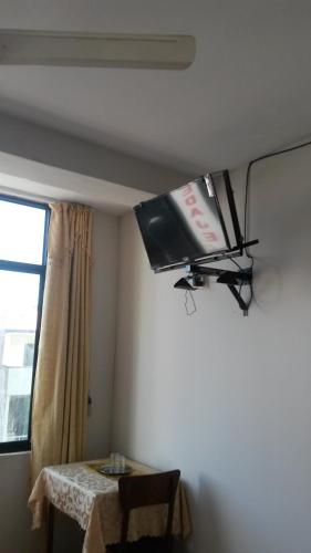 una televisione appesa al soffitto di una camera con tavolo di Casa del Huesped - Guest House a Pucallpa