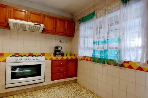 a small kitchen with a stove and a window at Casa Limón, es tu casa, tu grande residencia in Calvillo