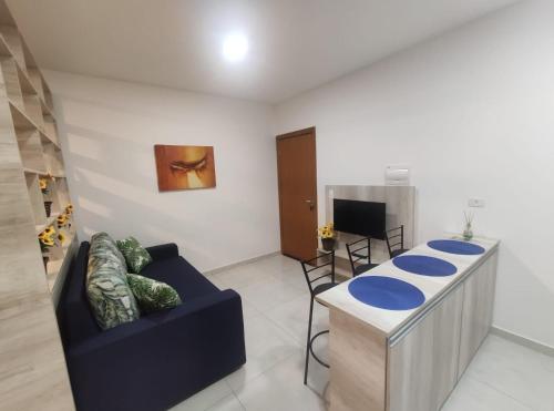 een woonkamer met een blauwe bank en een tafel bij Flat Brilho do Sol in Olímpia