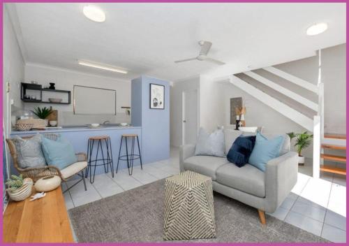 a living room with a couch and a kitchen at Walk to Strand Sleeps*4 2 Bedroom 1.5 Bath Central Location in Townsville