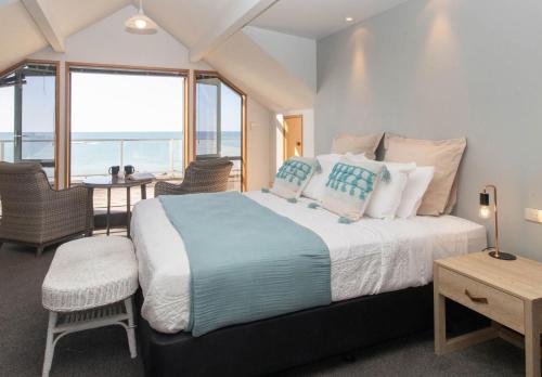 a bedroom with a bed with a view of the ocean at Beachfront Bliss On Wanaka Terrace Support Local in New Plymouth