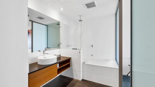 a white bathroom with a sink and a tub at Sea Side 211 in Mandurah