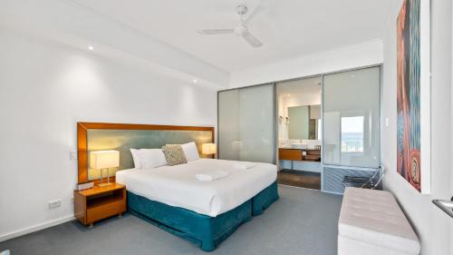 a bedroom with a large bed and a bathroom at Sea Side 211 in Mandurah