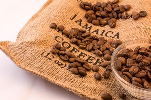 a sack of coffee beans next to a bowl of coffee beans at Jhadano 3br Pool & Gym Shuttle Gated in Florence Hall