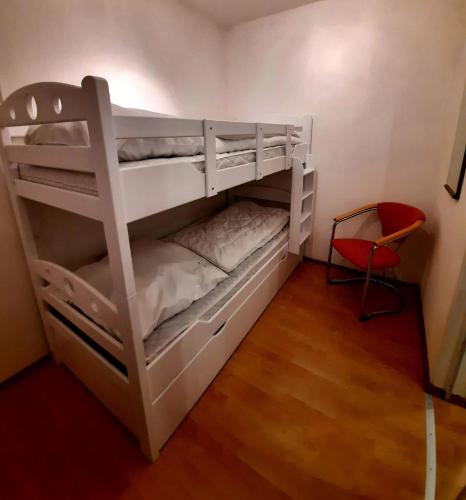 two bunk beds in a room with a red chair at Gipfelstürmer in Hahnenklee-Bockswiese